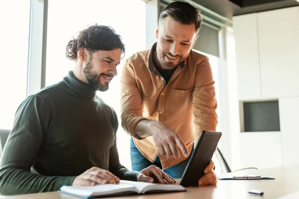 Modern ofiste tablet bilgisayar kullanan neşeli erkek arkadaşlar, boşluğu kopyalayın