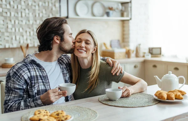 Yüzlerce yıldır gülümseyen beyaz koca sakallı sarılıp karısını yanağından öpüyor, kahve içiyor. — Stok fotoğraf