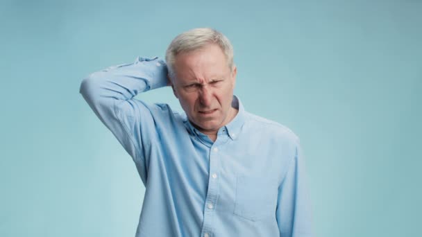 Hard problem. Pensive senior grey haired man thinking over solution, scratching his head and frowning face — Stock Video