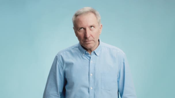 Fake information. Bored senior man rolling up eyes and frowning face, expressing tiredness and boredom, blue background — Stock Video