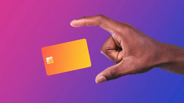 Mężczyzna trzyma kartę kredytową na fioletowym tle Neon, przycięte — Zdjęcie stockowe
