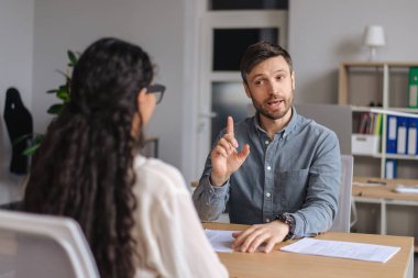 İki meslektaş iş fikirleri üzerinde kafa yoruyor, modern ofiste başlangıç projesini tartışıyorlar.