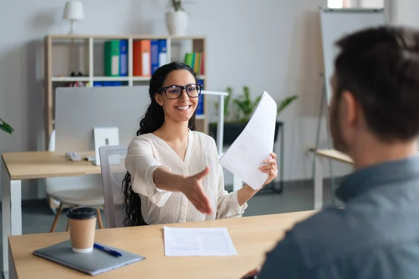 Happy HR manager in het bezit van CV, het aanbieden van handdruk aan sollicitant tijdens sollicitatiegesprek op modern kantoor — Stockfoto