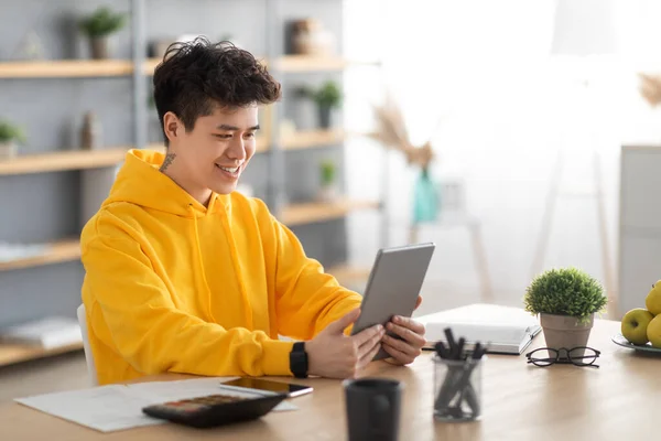 Sonriente asiático hombre usando digital tablet en casa —  Fotos de Stock