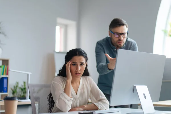 Boldogtalan fiatal női alkalmazott hibát követ el a projektben, lekési a határidőt, a főnöke leszidja az irodában. — Stock Fotó