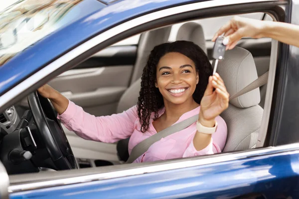 Feliz negro mujer sentado en nuevo coche tomando llaves — Foto de Stock