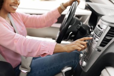 Gülümseyen siyah kadın şehirde yeni araba kullanıyor.