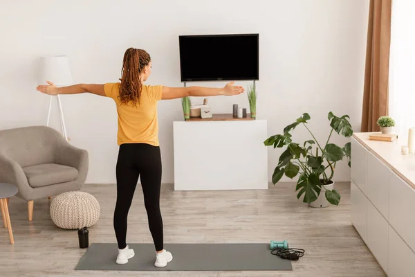 Africano Lady Stretching braços para lados tendo treino interno, Visão traseira — Fotografia de Stock