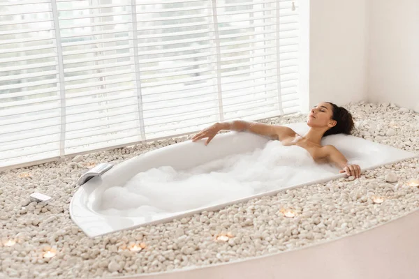 Pihenés és wellness. Teljes hossza csinos fiatal nő vesz habos fürdő, fekvő csukott szemmel fürdőkádban otthon — Stock Fotó