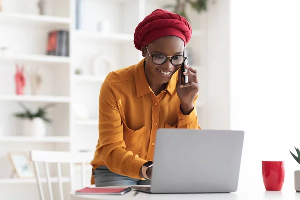 Positive black business lady consulting client on phone — Stock Photo, Image
