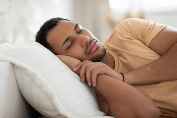 Arabski facet śpi leżąc w łóżku drzemie w nowoczesnej sypialni — Zdjęcie stockowe