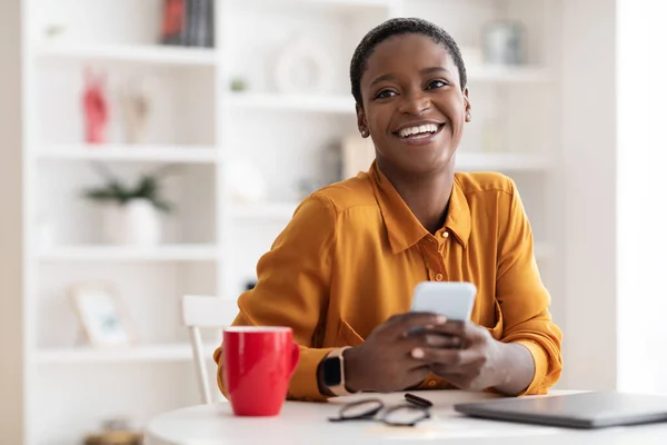 Attraente africana americana giovane imprenditrice godendo di business mobile app — Foto Stock