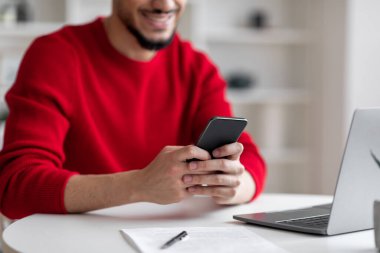 Dahili ofisteki bilgisayarında ve akıllı telefonunda yazan sakallı mutlu bin yıllık Arap işadamı...