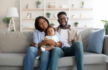 Mutlu siyah aile portresi evde gülümsüyor.