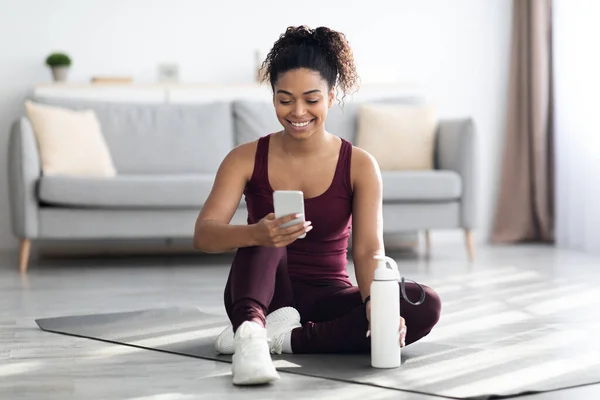 Glückliche athletische schwarze Frau beim Sport mit Handy — Stockfoto