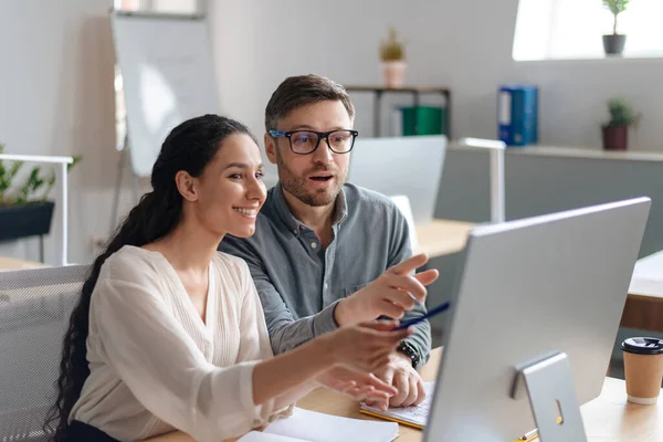 Positive Mitarbeiter zeigen auf Computerbildschirm, arbeiten an Geschäftsprojekt im modernen Büro, Kopierraum — Stockfoto