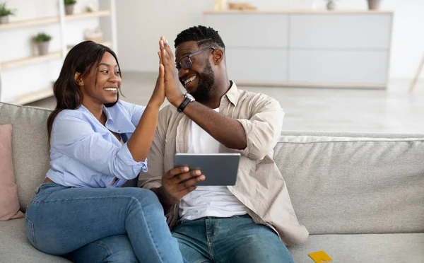 Šťastný černošky pár pomocí tablet, slaví vítězství dává vysoké pět — Stock fotografie