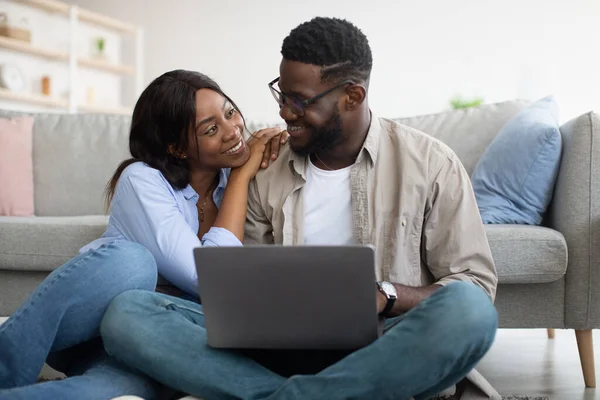 Porträt eines schwarzen Paares mit Computer im Wohnzimmer — Stockfoto
