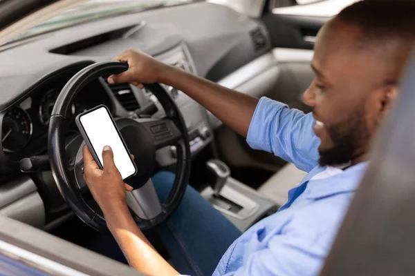 Szczęśliwy czarny człowiek za pomocą smartfona z pustym ekranem jazdy samochodem — Zdjęcie stockowe