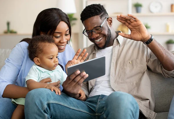 Feliz negro familia tener videocall usando tableta agitando manos — Foto de Stock