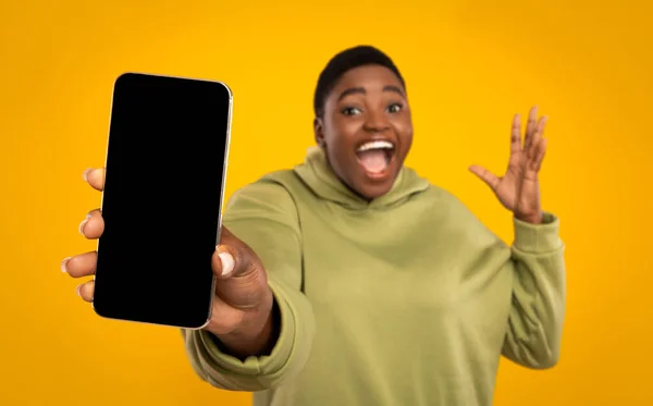 Emocional gordita africana americana mujer sosteniendo teléfono inteligente con pantalla en blanco — Foto de Stock