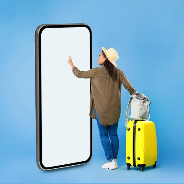 青の背景に巨大なスマートフォンを使用してアフリカの女性旅行者,スクエア — ストック写真