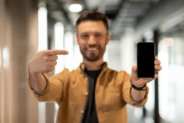 Businessman Arată Smartphone ecran gol în picioare în birou modern — Fotografie, imagine de stoc