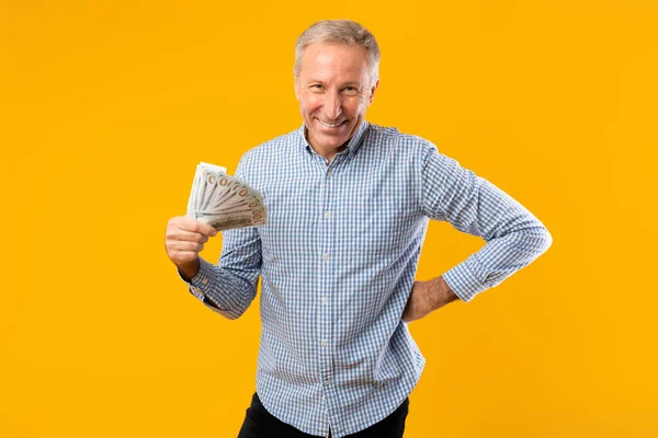 Vzrušený dospělý muž drží spoustu peněz v hotovosti — Stock fotografie