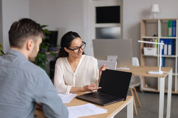 Positive männliche und weibliche Mitarbeiter diskutieren Geschäftsprojekt, verwenden Laptop mit Attrappe für Website-Design im Büro — Stockfoto
