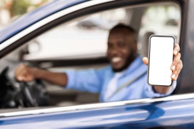 Boş ekranlı akıllı telefon kullanan mutlu siyah sürücü