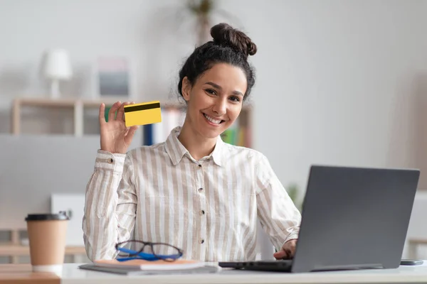 Portret van een gelukkige zakenvrouw met een creditcard terwijl ze online winkelen op de laptop computer en glimlachen om de camera — Stockfoto