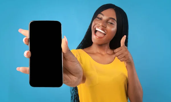 Mujer negra mostrando smartphone con pantalla en blanco y pulgar hacia arriba — Foto de Stock