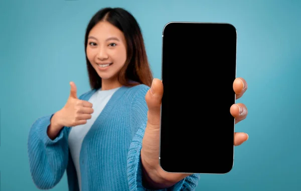 Asiatique dame montrant smartphone avec écran vide et pouce vers le haut — Photo