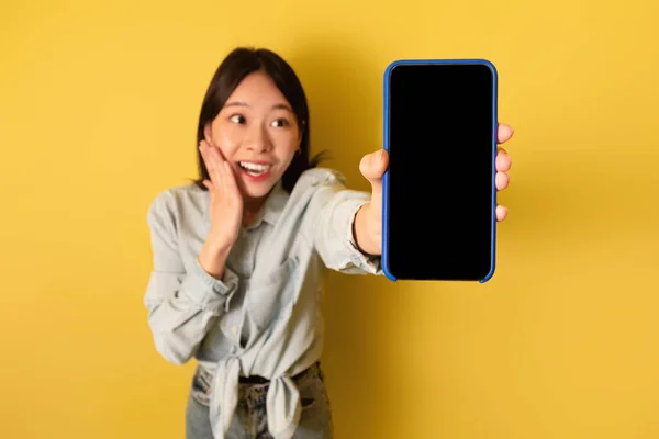 Excited millennial Asian lady presenting blank smartphone with mockup for mobile app or website design — 스톡 사진