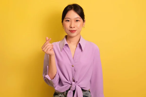 Saranghae. bela jovem ásia mulher fazendo coreano dedo mini coração gesto no amarelo estúdio fundo — Fotografia de Stock