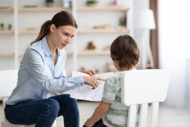 Çocukların psikolojik teşhislerinin modern yöntemleri. Küçük bir çocuğa resmi gösteren profesyonel bir kadın psikolog.