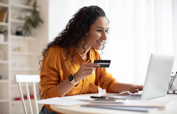 İş kadını İnternet 'ten alışveriş yapıyor. Kredi kartı ve iş yerinde dizüstü bilgisayar kullanıyor. — Stok fotoğraf