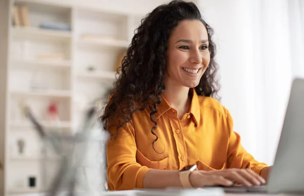 Alegre morena empresária usando laptop trabalhando no escritório moderno — Fotografia de Stock