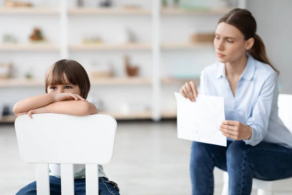 Masalah mental batin. Anak kecil yang stres duduk di kursi dan merasa kesal, mengabaikan psikoterapis profesional — Stok Foto