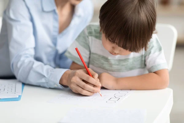 Навчання з раннього розвитку. Концентрований малюнок маленького хлопчика з вчителем у дитячому садку, вільний простір — стокове фото