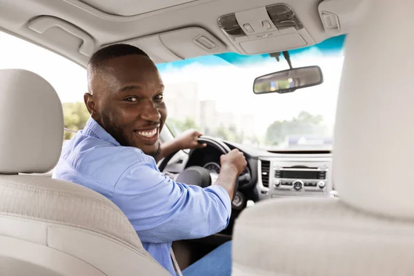 Mosolygó fekete férfi új autót vezet a városban visszafordul — Stock Fotó