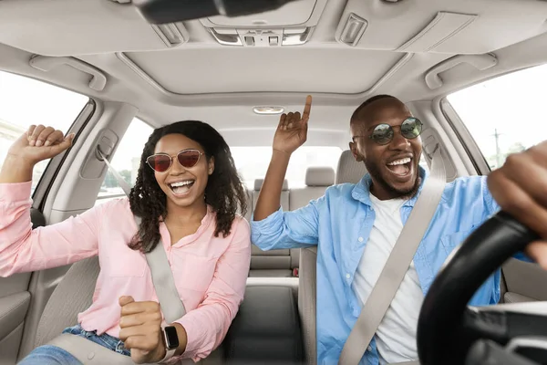 Glückliches schwarzes Paar genießt Musik am Steuer eines Luxusautos — Stockfoto