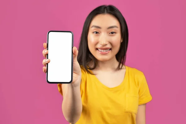 Cooles Angebot. Porträt einer glücklichen asiatischen Frau, die Handy mit leerem Bildschirm in der Hand hält, Gerät zur Kamera zeigt, Attrappe — Stockfoto