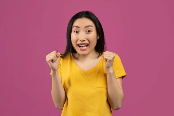 Oui, concept de réalisation. Joyeux asiatique femme acclamant et criant, célébrant la victoire sur fond violet — Photo