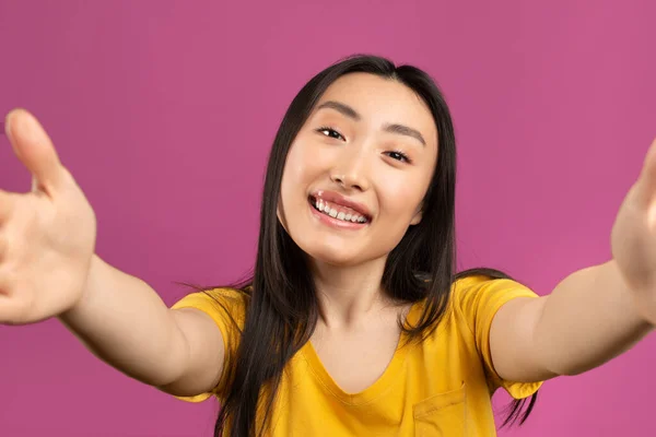 Blogger coreana dama haciendo selfie y sonriendo, posando ante la cámara en el estudio sobre fondo violeta — Foto de Stock