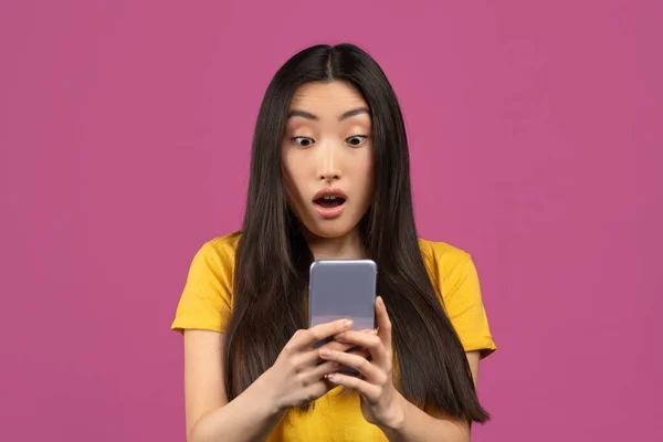 Portret van verrast Koreaanse dame op zoek naar smartphone scherm met opwinding, emotioneel reageren op mobiele aanbod — Stockfoto