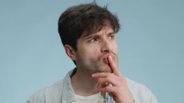 Yaratıcı düşünce. Düşünceli genç adam kafa yoruyor, kaşınıyor ve çözümü var, parmağını kaldırıp gülümsüyor.