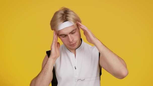 Jonge sportieve man dragen sport pak opwarmen voor de training, spinnen nek, gele studio achtergrond — Stockvideo