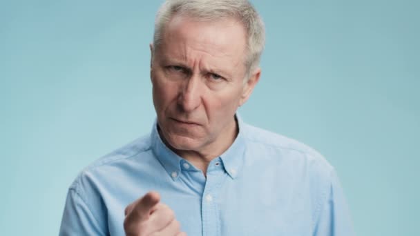 Reproach concept. Angry senior grey haired man scolding with finger, blaming and looking grumpily to camera — Stock Video