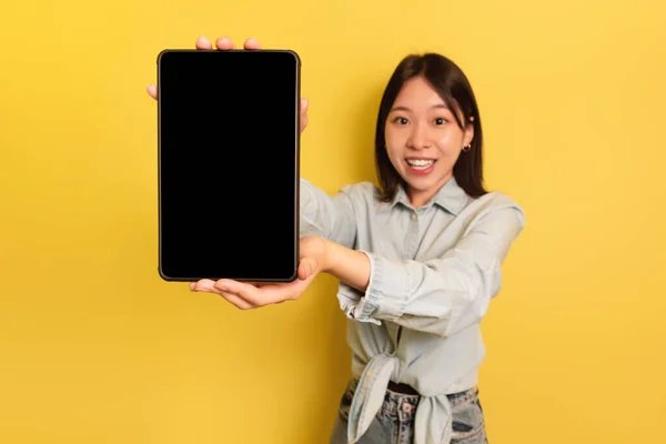Çekici Asyalı kadın elinde boş ekranlı dijital tablet tutuyor. En yeni mobil uygulamayı öneriyor. — Stok fotoğraf
